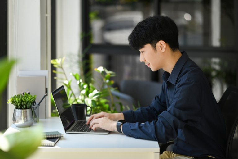 ノートパソコンで作業している若い男性